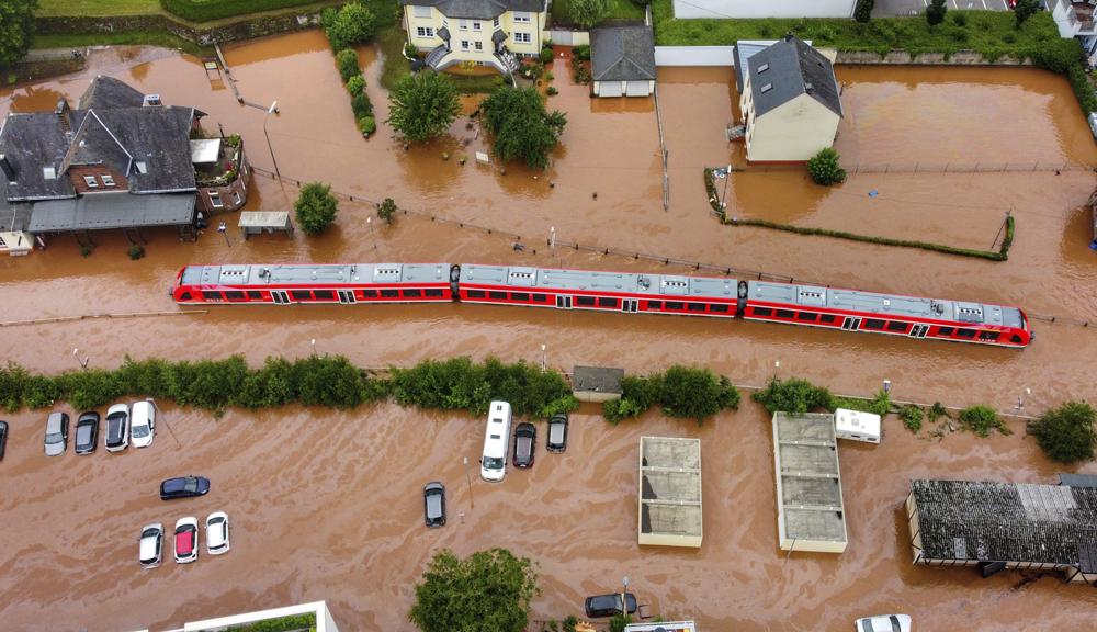 A regional train sits in the flood waters at the local station in Kordel, Germany, Thursday July 15, 2021 after it was flooded by the high waters of the Kyll river. (Sebastian Schmitt/dpa via AP)