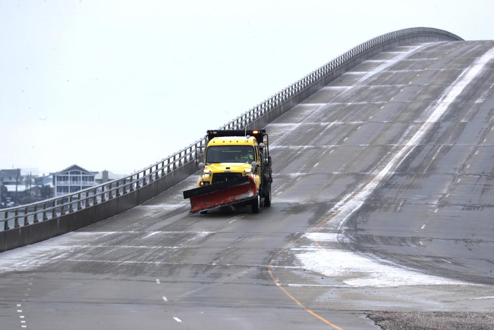 Un camión trata el hielo en el puente de Atlantic Beach después de que una tormenta invernal azotara Carolina del Norte en Morehead City, NC, el sábado 22 de enero de 2022. Una capa de hielo y un manto de nieve han cubierto las áreas costeras que se extienden desde Carolina del Sur hasta Virginia .  El sistema de clima invernal que ingresó a la región el viernes trajo temperaturas más frías y precipitaciones que no se ven con frecuencia en la región.  (Foto AP/Tom Copeland)