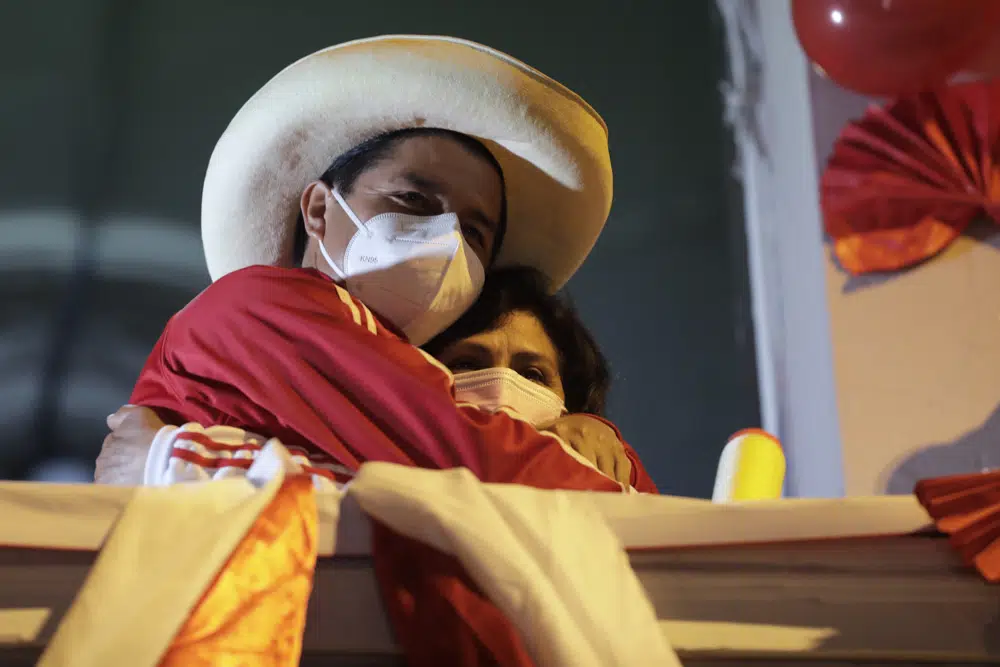 FILE - Pedro Castillo hugs his wife Lilia Paredes Navarro as he stands before supporters at his closing campaign rally in Lima, Peru, June 3, 2021. (AP Photo/Guadalupe Pardo, FIle)