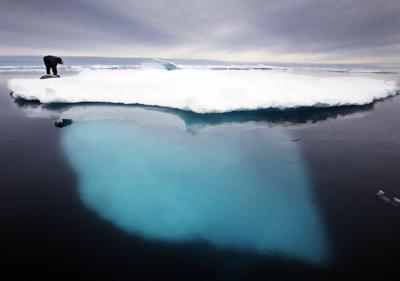 ARCHIVO - En esta foto de julio del 2007, un cazador de focas inuit toca una foca muerta sobre un iceberg derretido cerca de la isla de Ammassalik, en Groenlandia. (AP Foto/John McConnico)