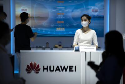 Una empleada atiende un stand de la firma china Huawei durante la Feria Internacional de Comercio de Servicios de China (CIFTIS) en Beijing, el viernes 3 de septiembre de 2021. (AP Foto/Mark Schiefelbein)
