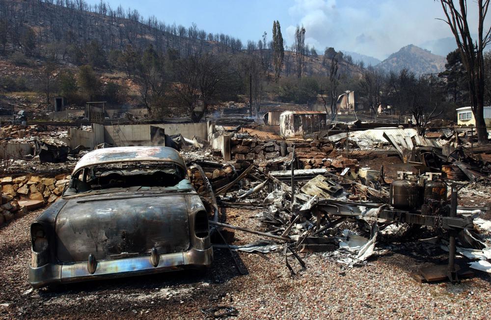 ARCHIVO - Se muestra el daño del incendio Coal Seam en Glenwood Springs, Colorado, el 9 de junio de 2002. Un área en las afueras de Denver donde el incendio forestal más destructivo en la historia de Colorado quemó 1,000 casas el mes pasado alberga numerosas minas de carbón abandonadas que, según las autoridades, podrían ser una causa potencial del incendio forestal impulsado por el viento.  La historia muestra que el carbón en descomposición ha provocado incendios antes, incluso cerca del mismo lugar al sur de Boulder en 2005, cuando un respiradero caliente de una mina en llamas provocó un incendio forestal que se extinguió rápidamente.  El incendio de una mina de carbón también provocó un incendio en la ciudad montañosa de Glenwood Springs, en Colorado, que quemó 29 casas en 2002. (Foto AP/Peter M. Fredin, archivo)