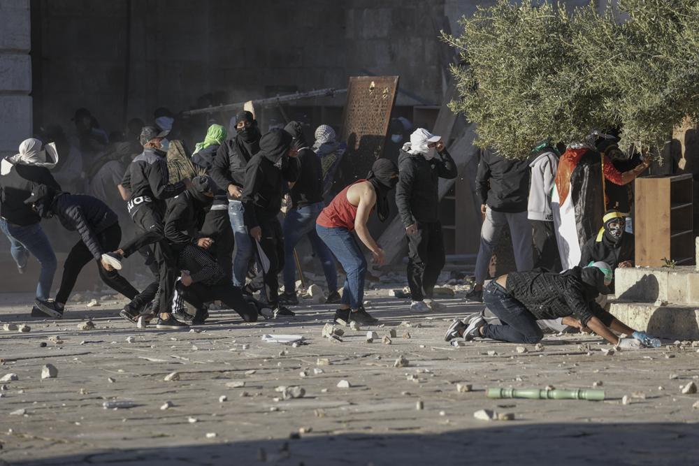 Palestinos chocan con las fuerzas de seguridad israelíes en el complejo de la mezquita de Al Aqsa en la Ciudad Vieja de Jerusalén el viernes 15 de abril de 2022. (AP Photo/Mahmoud Illean)