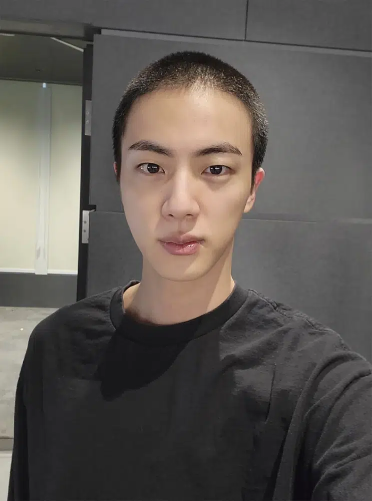 In this photo provided by Weverse, Jin of K-pop band BTS shows off freshly shaved hair on the K-pop social media platform Weverse, which was uploaded Sunday, Dec. 11, 2022, ahead of his upcoming military conscription. Jin, the oldest member of K-pop supergroup BTS, was set to enter a frontline South Korean boot camp Tuesday to start his 18 months of mandatory military service, as fans gathered near the base to say goodbye to their star. (Weverse via AP)