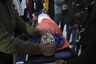Dolientes rodean el cuerpo del palestino de 16 años Mustafa Sabah durante su funeral en el pueblo de Tuqu, cerca de la ciudad de Belén, en Cisjordania, el viernes 28 de abril de 2023. (AP Foto/Mahmoud Illean)