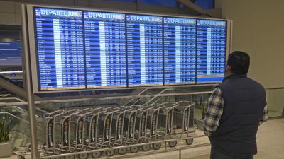 Un hombre observa las pantallas de salidas de vuelos en el Aeropuerto Internacional de Salt Lake City, el viernes 24 de diciembre de 2021. (AP Foto/Rick Bowmer)