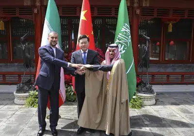 En esta imagen, distribuida por el Ministerio de Exteriores de Irán, el canciller iraní, Hossein Amirabdollahian (izquierda), estrecha la mano a sus homólogos de Arabia Saudí, el príncipe Faisal bin Farhan Al Saud (derecha), y China, Qin Gang, en Beijing, el 6 de abril de 2023. (Ministerio de Exteriores de Irán vía AP)
