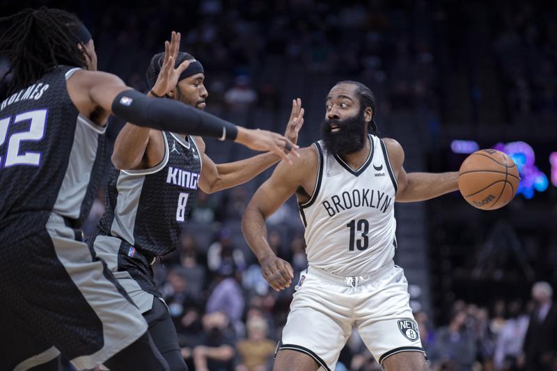 Brooklyn Nets guard James Harden (13) is double-teamed by Sacramento Kings forward Maurice Harkless (8) and center Richaun Holmes (22) during the first quarter of an NBA basketball game in Sacramento, Calif., Wednesday, Feb. 2, 2022. (AP Photo/José Luis Villegas)