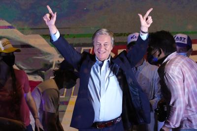 El candidato presidencial del Partido Republicano, José Antonio Kast, hace gestos a sus partidarios en la sede de su campaña luego de que cerraron las urnas y se anunciaron resultados parciales en Santiago, Chile, el domingo 21 de noviembre de 2021. (AP Foto / Esteban Félix)