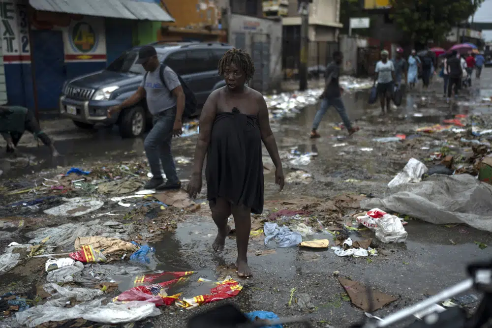 A woman walks on a street after a rain storm in Port-au-Prince, Haiti, Saturday, June 3, 2023. (AP Photo/Ariana Cubillos)