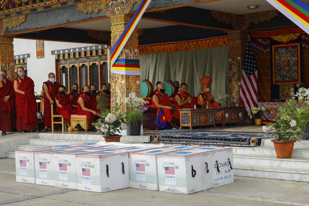 This photograph provided by UNICEF shows monks from Paro's monastic body perform prayers as 500,000 doses of Moderna COVID-19 vaccine gifted from the United States arrived at Paro International Airport in Bhutan, July 12, 2021. The Himalayan kingdom of Bhutan has fully vaccinated 90% of its eligible adult population within just seven days, its health ministry said Tuesday. (UNICEF via AP)