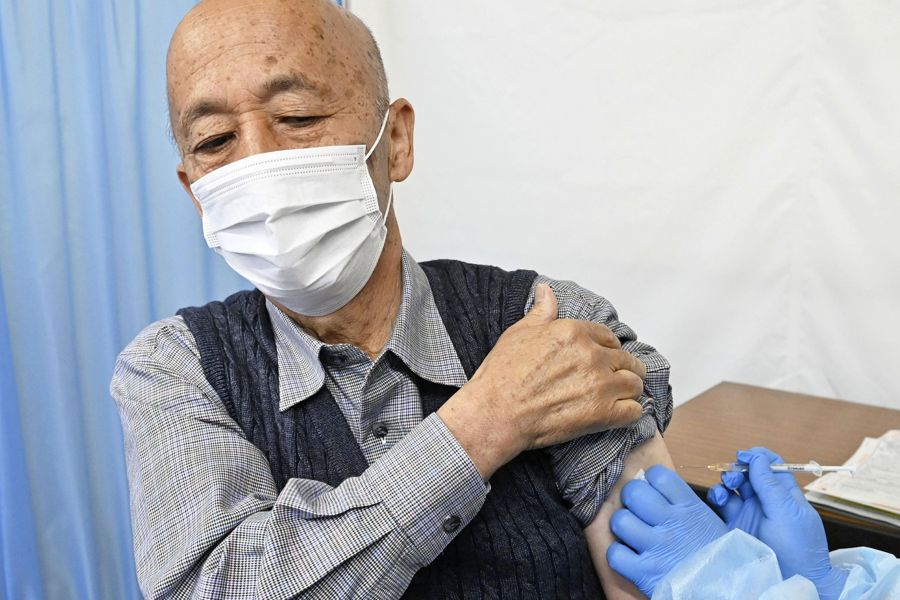 Tokyo adopts tougher virus rules and begins vaccinating the elderly