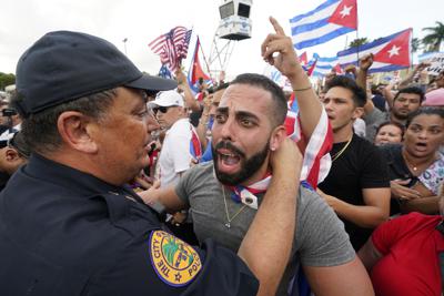 Foto tomada el 14 de julio del 2021 del jefe policial de Miami Art Acevedo (izq) abrazando a un manifestante que protestaba contra el gobiero cubano, en La Pequeña Habana, en Miami. (Foto AP/Wilfredo Lee, File)