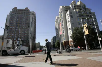 ARCHIVO - Un hombre pasa frente a edificio en el distrito Fillmore de San Francisco, 15 de octubre de 2008. Concejales en San Francisco estudian un proyecto de indemnizar con 5 millones de dólares a cada persona negra descendiente de esclavos, en una audiencia el martes 14 de marzo de 2023. (AP Photo/Jeff Chiu, File)