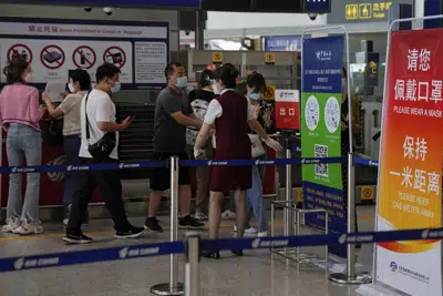 ARCHIVO - Una trabajadora aérea pide a los viajeros que declaren su información de salud tras facturar en el mostrador de vuelos internacionales en el aeropuerto internacional Capital Beijing, en Beijing, el 24 de agosto de 2022. (AP Foto/Andy Wong, Archivo)