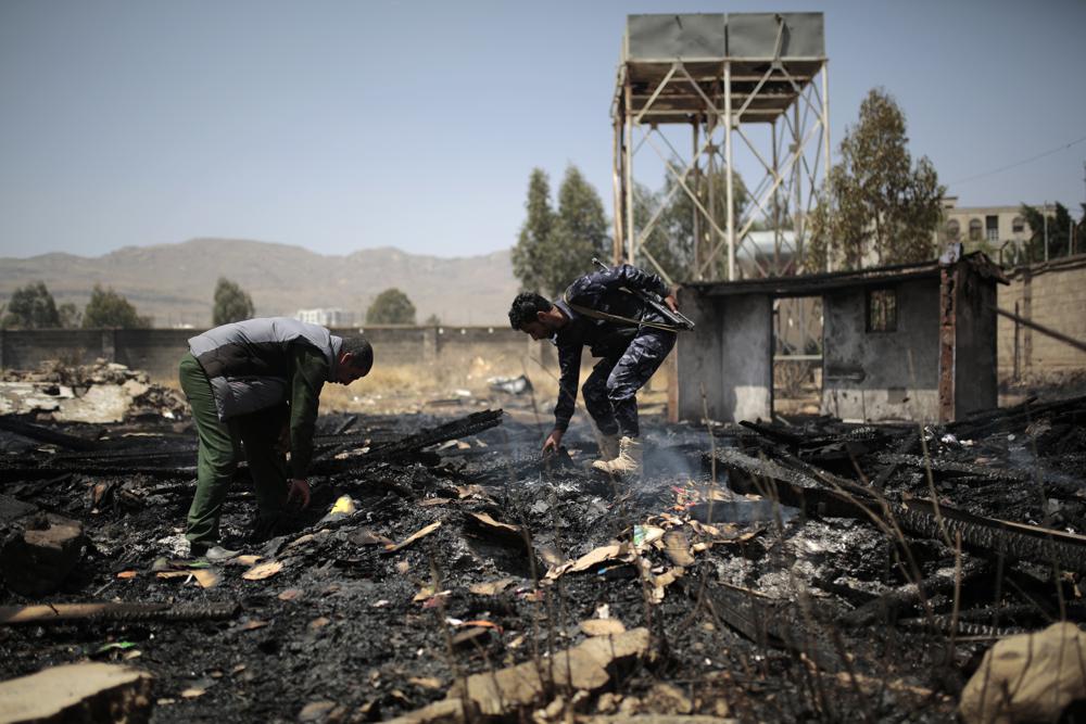 Yemeni police inspect a site of Saudi-led airstrikes targeting two houses in Sanaa, Yemen, Saturday, March 26, 2022. A Houthi media office claimed an airstrike hit houses for guards of the social insurance office, killing at least seven people and wounding three others, including women and children. (AP Photo/Hani Mohammed)