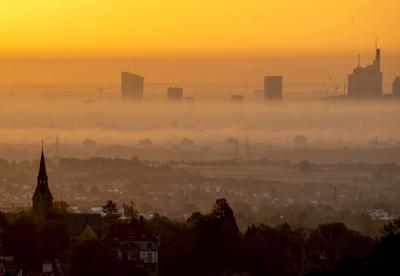 La iglesia de Kronberg, a la izquierda, se ve sobre los edificios del distrito bancario en Fráncfort, Alemania, en una mañana de niebla el lunes 31 de octubre de 2022.  (AP Foto/Michael Probst)