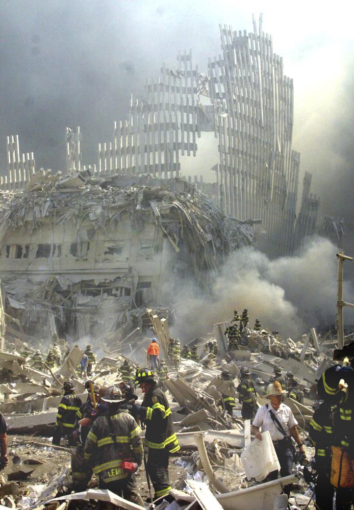 FILE - In this Sept. 11, 2001 file photo, a shell of what was once part of the facade of one of the twin towers of New York's World Trade Center rises above the rubble that remains after both towers were destroyed in the terrorist attacks. Rescuers who responded to past disasters say the search for victims of the Florida condo collapse that occurred on June 24, 2021, brought back memories of the Oklahoma City bombing and the Sept. 11 attacks. (AP Photo/Shawn Baldwin, File)