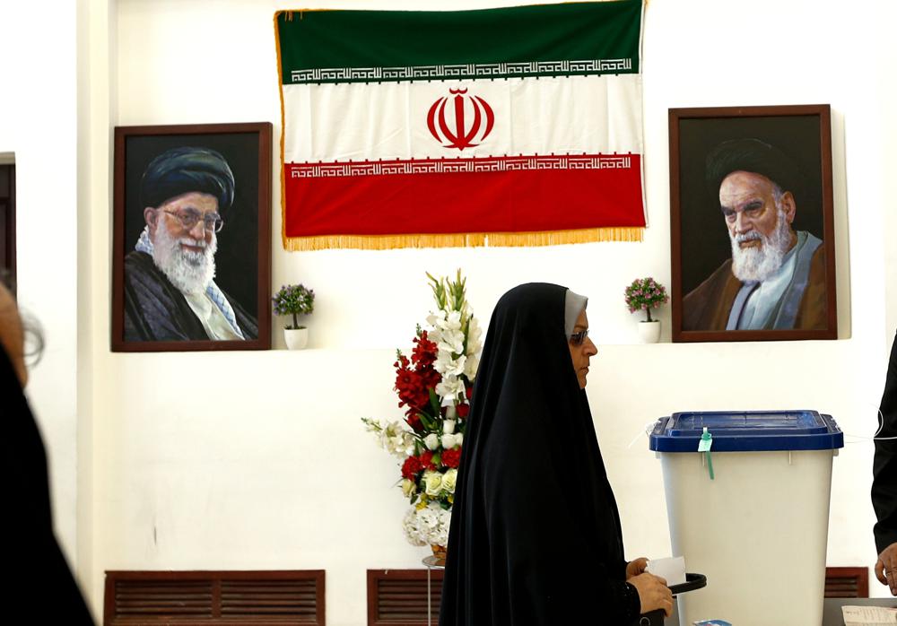 A woman casts her vote during the presidential election at a polling station inside the Iranian consulate in Karbala, Iraq, Friday, June 18, 2021. Iran began voting Friday in a presidential election tipped in the favor of a hard-line protege of Supreme Leader Ayatollah Ali Khamenei, fueling public apathy and sparking calls for a boycott in the Islamic Republic. (AP Photo/Hadi Mizban)