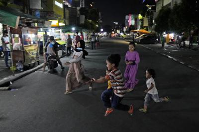 Varios niños juegan en una calle el lunes 21 de junio de 2021, en Yakarta, Indonesia. (AP Foto/Dita Alangkara)