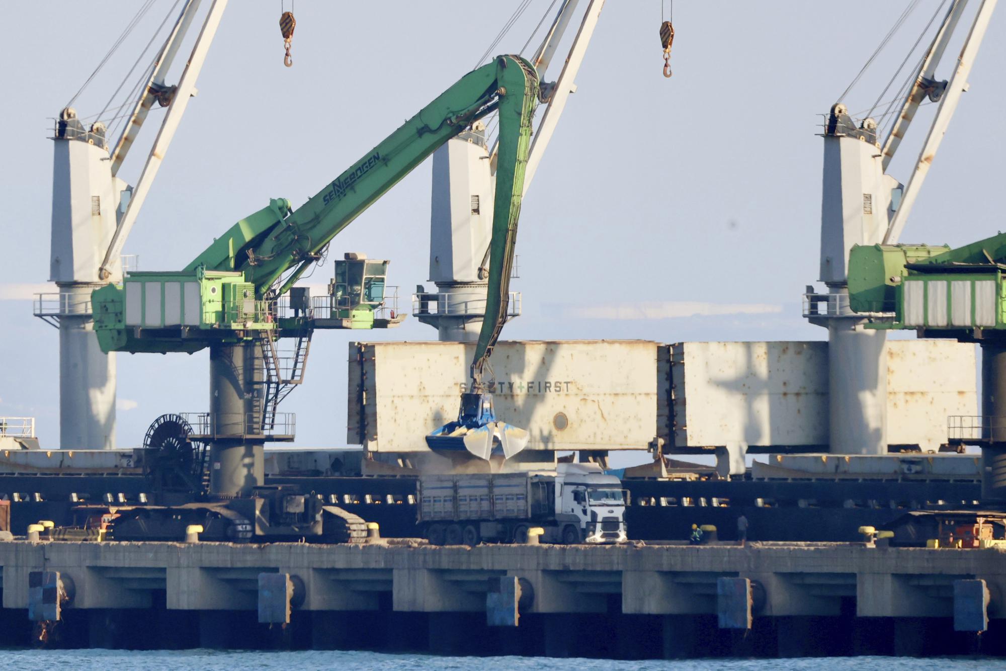 Grain from the cargo ship Mikhail Nenashev is loaded onto trucks at a Russian-owned steel mill in Dörtyol, Turkey on June 27, 2022. An Associated Press investigation shows the ship, owned by sanctioned Russian state-owned defense contractor, is part of an extensive Russian-run smuggling operation that has been hauling stolen Ukrainian grain from ports in occupied Crimea to customers in the Middle East. (AP Photo/Yoruk Isik)