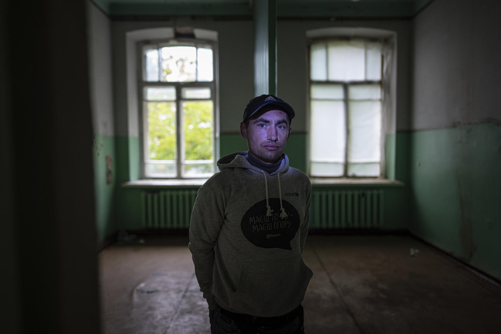 Mykola Mosyakyn stands in a room of a former medical clinic where Russian forces tortured him in the recently liberated town of Izium, Ukraine, Friday, Sept. 23, 2022. He was beaten repeatedly, his feet shot, and he described how they covered his face with a rag and poured water from a kettle onto him to mimic the sensation of drowning. (AP Photo/Evgeniy Maloletka)