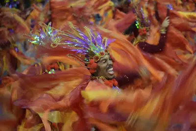 Un bailarín de la escuela de samba Dragoes da Real actúa durante un desfile de Carnaval en Sao Paulo, Brasil, el 19 de febrero de 2023. (AP Foto/Andre Penner)