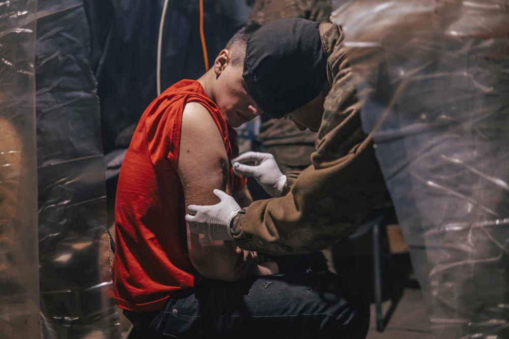 In this photo provided by Azov Special Forces Regiment of the Ukrainian National Guard Press Office, an Azov Special Forces Regiment's serviceman, injured during fighting against Russian forces, poses for a photographer inside the Azovstal steel plant in Mariupol, Ukraine, Tuesday, May 10, 2022. (Dmytro 'Orest' Kozatskyi/Azov Special Forces Regiment of the Ukrainian National Guard Press Office via AP)