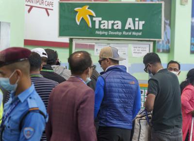 Una señalización de Tara Airlines se ve detrás mientras un equipo de escaladores se prepara para partir para las operaciones de rescate desde el Aeropuerto Internacional Tribhuvan en Katmandú, Nepal, el domingo 29 de mayo de 2022. Un pequeño avión con 22 personas a bordo volando en una popular ruta turística desapareció en las montañas de Nepal el domingo, dijo un funcionario. El avión de Tara Airlines, que estaba en un vuelo programado de 15 minutos a la ciudad montañosa de Jomsom, despegó de la ciudad turística de Pokhara, a 200 kilómetros (125 millas) al este de Katmandú. Perdió contacto con la torre del aeropuerto poco después del despegue. (AP Photo/Niranjan Shreshta)