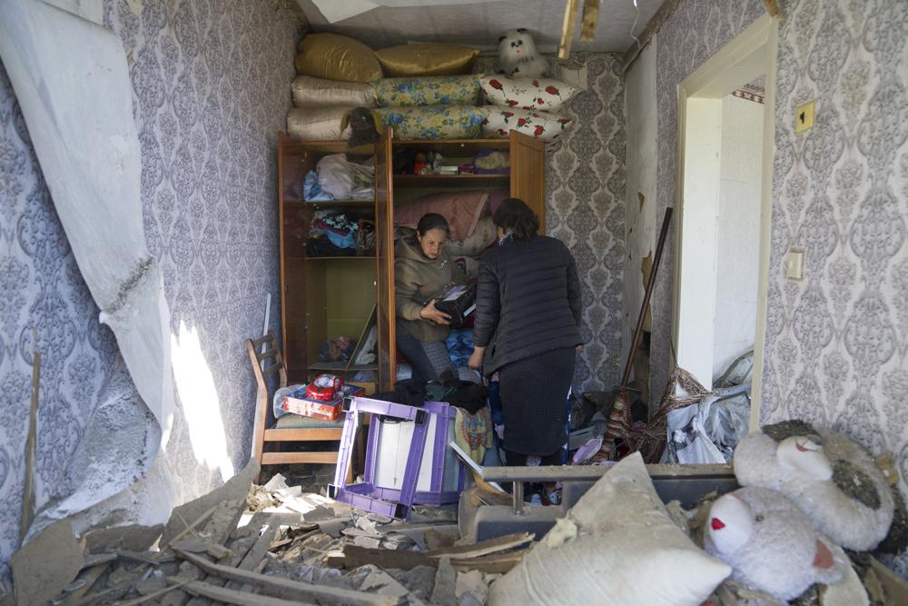 Women collect belongings in their apartment destroyed by Russian airstrike in Bakhmut, Donetsk region, Ukraine, Saturday, May 7, 2022. (AP Photo/Evgeniy Maloletka)