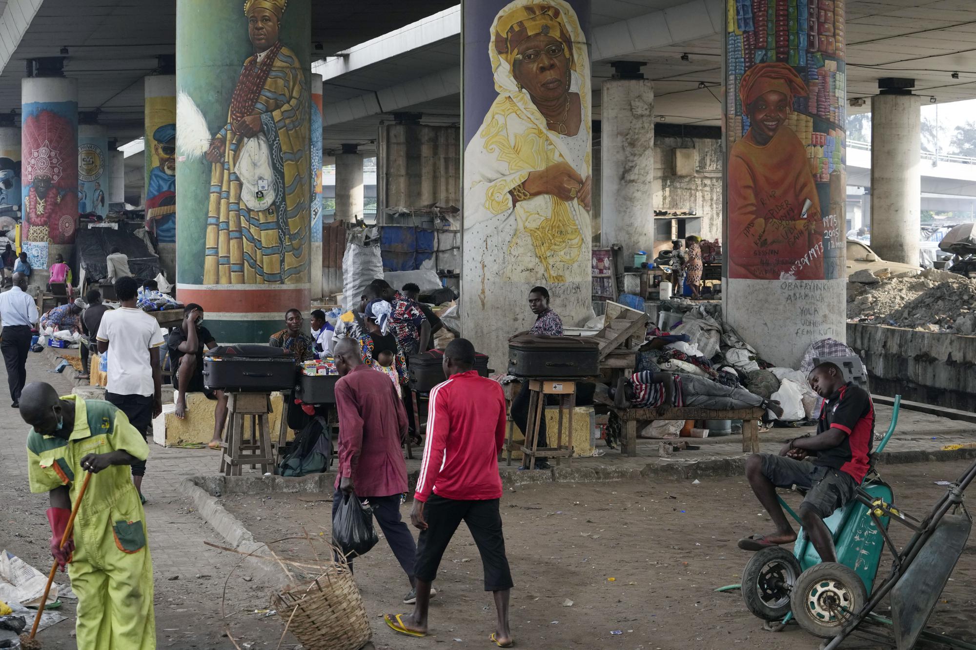 People walk during rush hours in Lagos, Nigeria, Monday, Nov. 14, 2022. The world's population is projected to hit an estimated 8 billion people on Tuesday, Nov. 15, according to a United Nations projection, with much of the growth coming from developing nations in Africa. (AP Photo/Sunday Alamba)