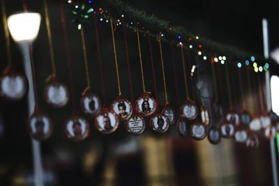 Adornos navideños con imágenes de personas desaparecidas cuelgan en el Jardín Memorial colocado por parientes de las víctimas en un parque ante el edificio de gobierno de la ciudad de Iztacalco, en Ciudad de México, el martes 14 de diciembre de 2021. (AP Foto/Marco Ugarte)