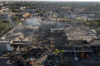 Bomberos del Servicio Ucraniano de Emergencias trabajan para retirar los escombros de un centro comercial calcinado tras el impacto de un cohete de en Kremenchuk, Ucrania, el martes 28 de junio de 2022. (AP Foto/Efrem Lukatsky)