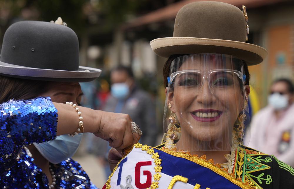 Una mujer con un protector facial para frenar la propagación del nuevo coronavirus sonríe durante la inauguración de las celebraciones del Carnaval en La Paz, Bolivia, el domingo 6 de febrero de 2022. (AP Foto/Juan Karita)