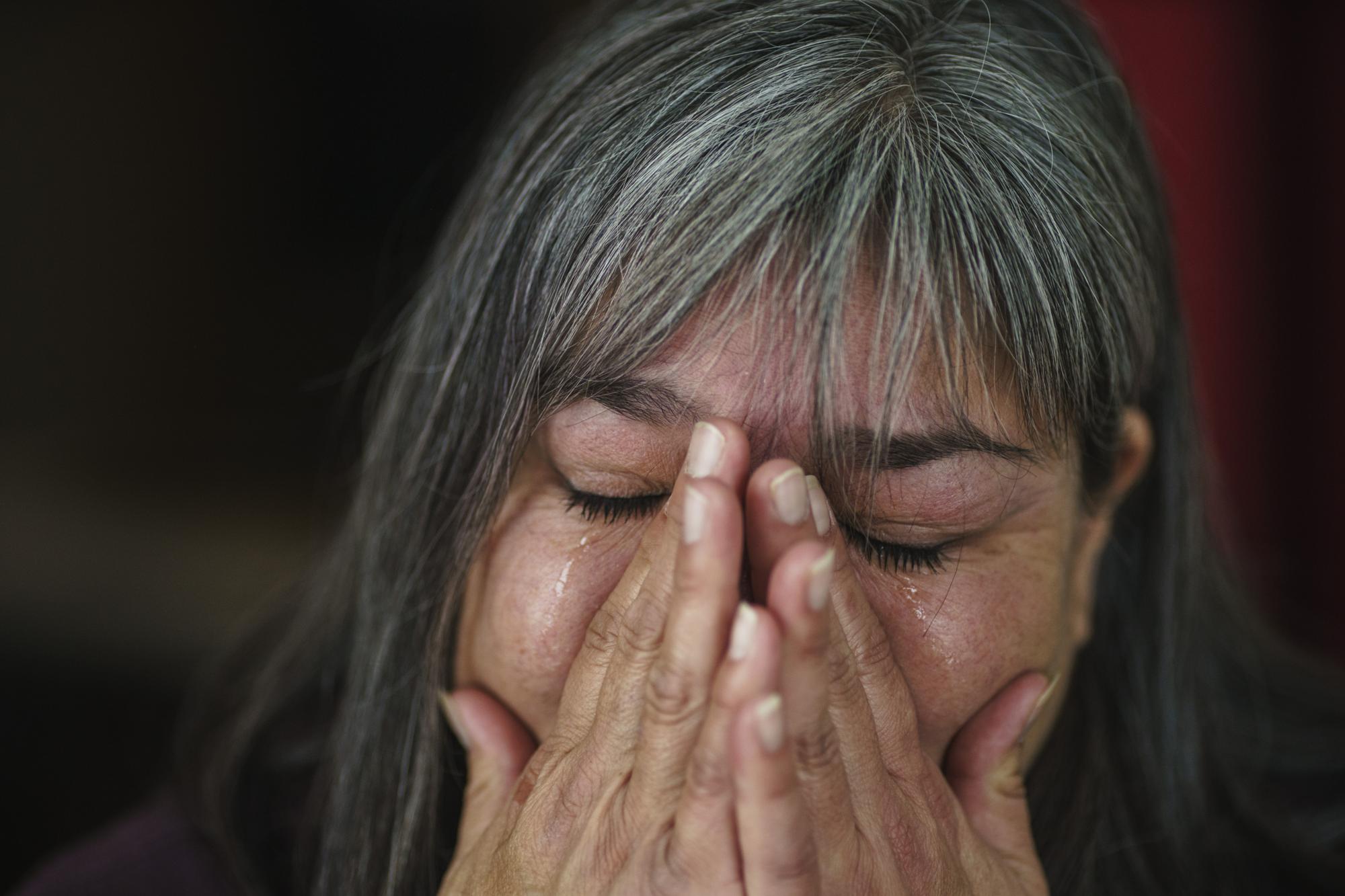Rachel Taylor weeps while talking about her son, Kyle Domrese, who died of a drug overdose in January, as she sits in the home they shared in Bemidji, Minn., Wednesday, Nov. 17, 2021. In January, Taylor's heart began aching, like someone had reached into her chest and was squeezing it. "It was like my heart knew before I did," she said. "My heart was broken four days before he even died." She had an uneasy feeling the morning of Jan. 11. It was quiet in the house and her son's bedroom door was closed. (AP Photo/David Goldman)