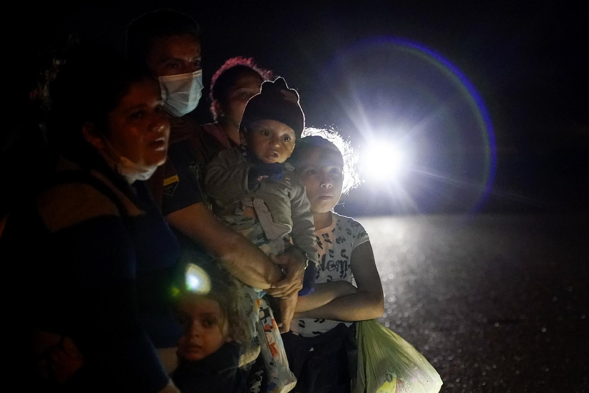 FILE - A group of migrants mainly from Honduras and Nicaragua wait along a road after turning themselves in upon crossing the U.S.-Mexico border, in La Joya, Texas, May 17, 2021. Biden took office on Jan. 20 and almost immediately, numbers of migrants exceeded expectations. (AP Photo/Gregory Bull, File)