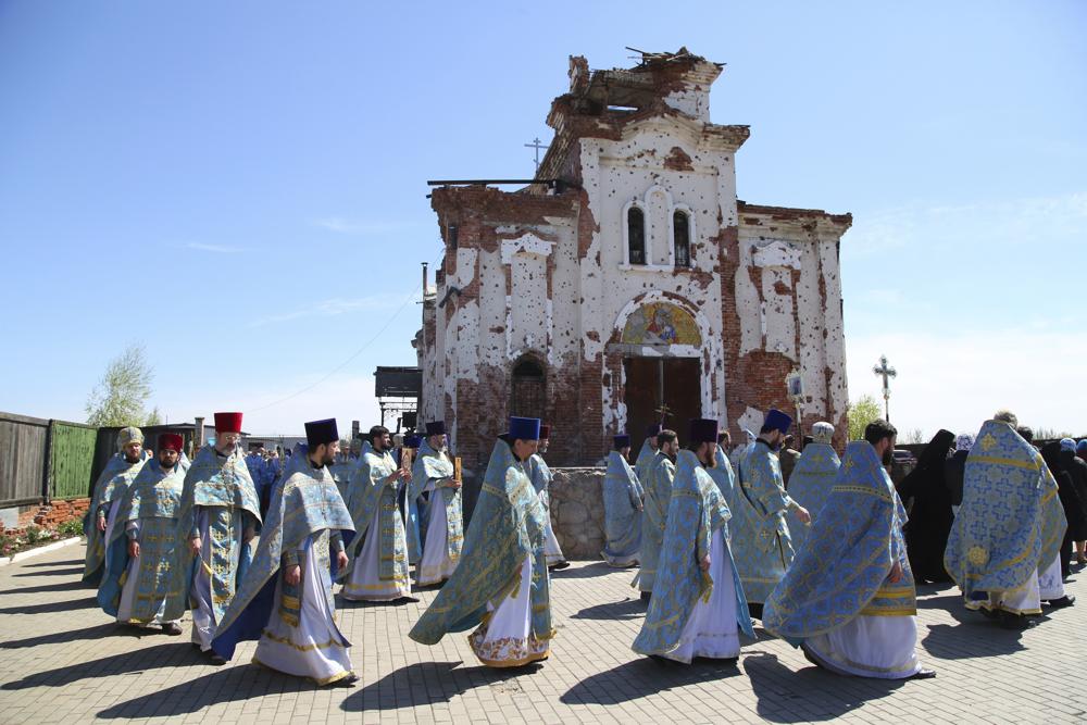 FILE - Priests participate in a procession celebrating Orthodox Easter at the Iversky Monastery, a monastery of the Ukrainian Orthodox Church (Moscow Patriarchate) damaged by shelling, outside Donetsk, Ukraine, Tuesday, May 4, 2021. (AP Photo/Alexei Alexandrov, File)