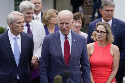 El presidente Joe Biden, acompañado de un grupo bipartidista de senadores, hace declaraciones afuera de la Casa Blanca en Washington, el jueves 24 de junio de 2021. (AP Foto/Evan Vucci)