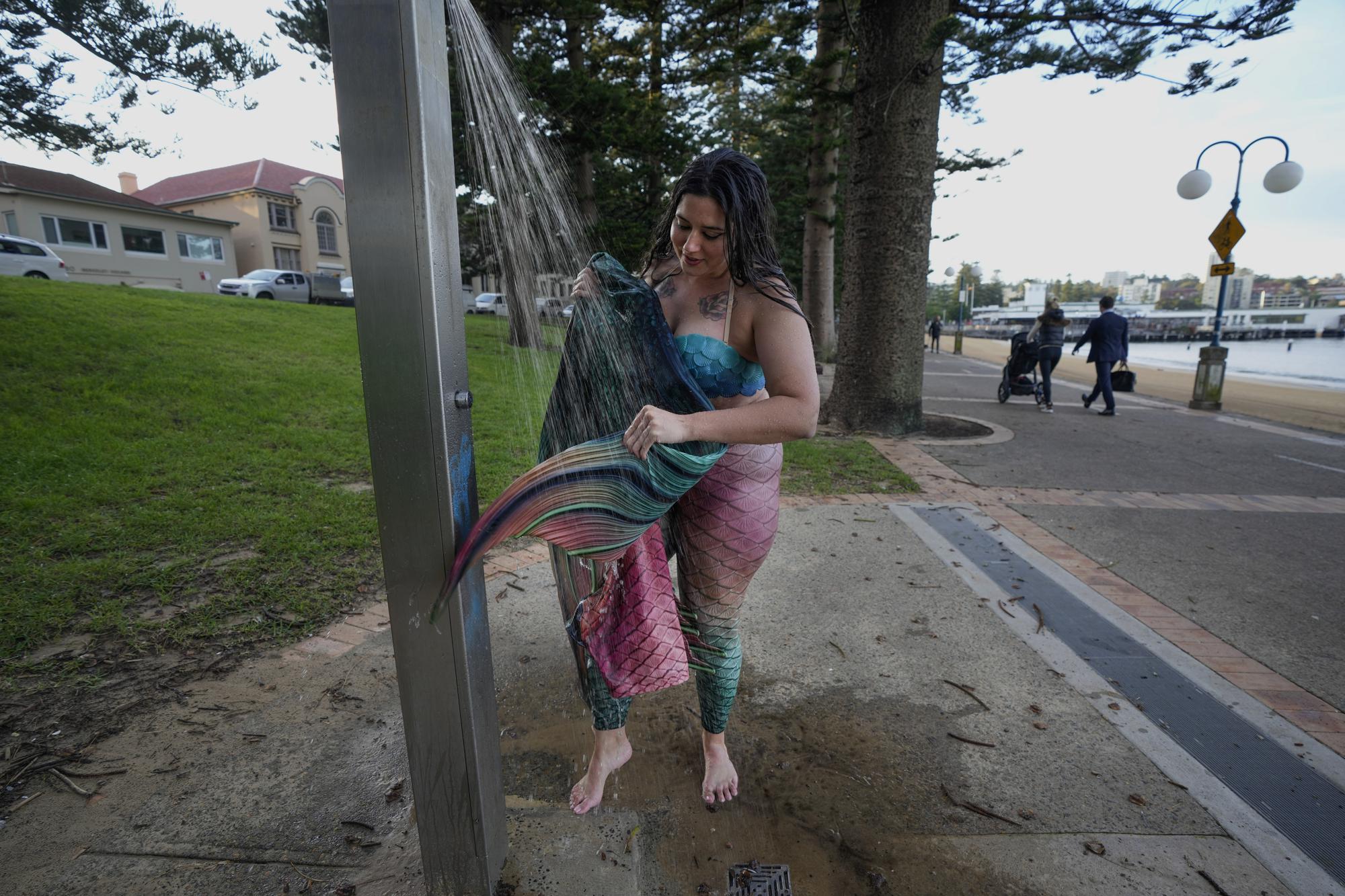Lauren Metzler, founder of Sydney Mermaids, washes her tail after a swim at Manly Cove Beach in Sydney, Australia, Thursday, May 26, 2022. Across the world, people are increasingly embracing the subculture of “mermaiding.” At its simplest, these are humans of all genders, shapes and backgrounds who enjoy dressing up as mermaids. (AP Photo/Mark Baker)