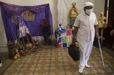 El sacerdote de la santería Lázaro Cuesta permanece de pie tras leer la "Letra del Año", el domingo 2 de enero de 2022, en La Habana, Cuba. Dicha "Letra" anual es un conjunto de predicciones para los próximos 12 meses. (AP Foto/Ismael Francisco)