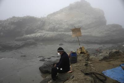 ARCHIVO - El pescador Walter de la Cruz se sienta en la orilla de la playa Cavero manchada de petróleo, incapaz de pescar después de un derrame en el distrito de Ventanilla de Callao, Perú, el 21 de enero de 2022. De la Cruz, de 60 años, es uno de los más de 2.500 pescadores cuyos medios de vida han sido puestos en duda como resultado de un gran derrame de petróleo crudo por parte de la refinería de petróleo Repsol, de propiedad española, el 15 de enero. (AP Foto/Martín Mejía, Archivo)