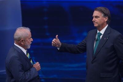 El expresidente brasileño Luiz Inácio Lula da Silva, quien busca ocupar nuevamente el cargo, a la izquierda, se enfrenta al mandatario Jair Bolsonaro en un debate en la cadena Bandeirantes Television, el domingo 16 de octubre de 2022, en Sao Paulo. (AP Foto/Marcelo Chello)