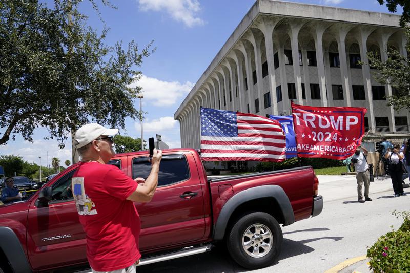 A vehicle with flags in support of Donald Trump drives outside of the Paul G. Rogers Federal Courthouse, Thursday, Aug. 18, 2022, in West Palm Beach, Fla. Attorneys for the nation's largest media companies are presenting their case before a federal magistrate judge to make public the affidavit supporting the warrant that allowed FBI agents to search former President Donald Trump's Mar-a-Lago estate in Florida. (AP Photo/Lynne Sladky)