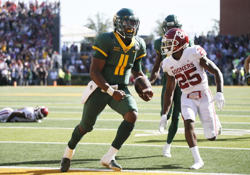 Baylor quarterback Gerry Bohanon (11) scores on a 14-yard touchdown carry as he gets by Oklahoma Sooners defensive back Justin Broiles (25) during the second half of an NCAA college football game in Waco, Texas, Saturday, Nov. 13, 2021. (AP Photo/Ray Carlin)