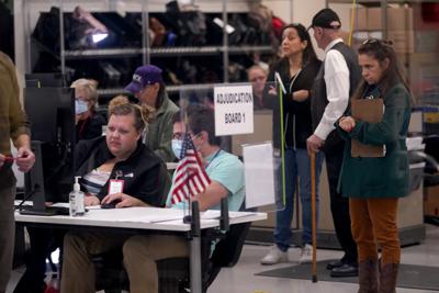 Árbitros y observadores de elecciones miran la tabulación de boletas dentro de la Oficina de Registros del Condado Maricopa, en Phoenix, Arizona, el 10 de noviembre del 2022. (AP Foto/Matt York)