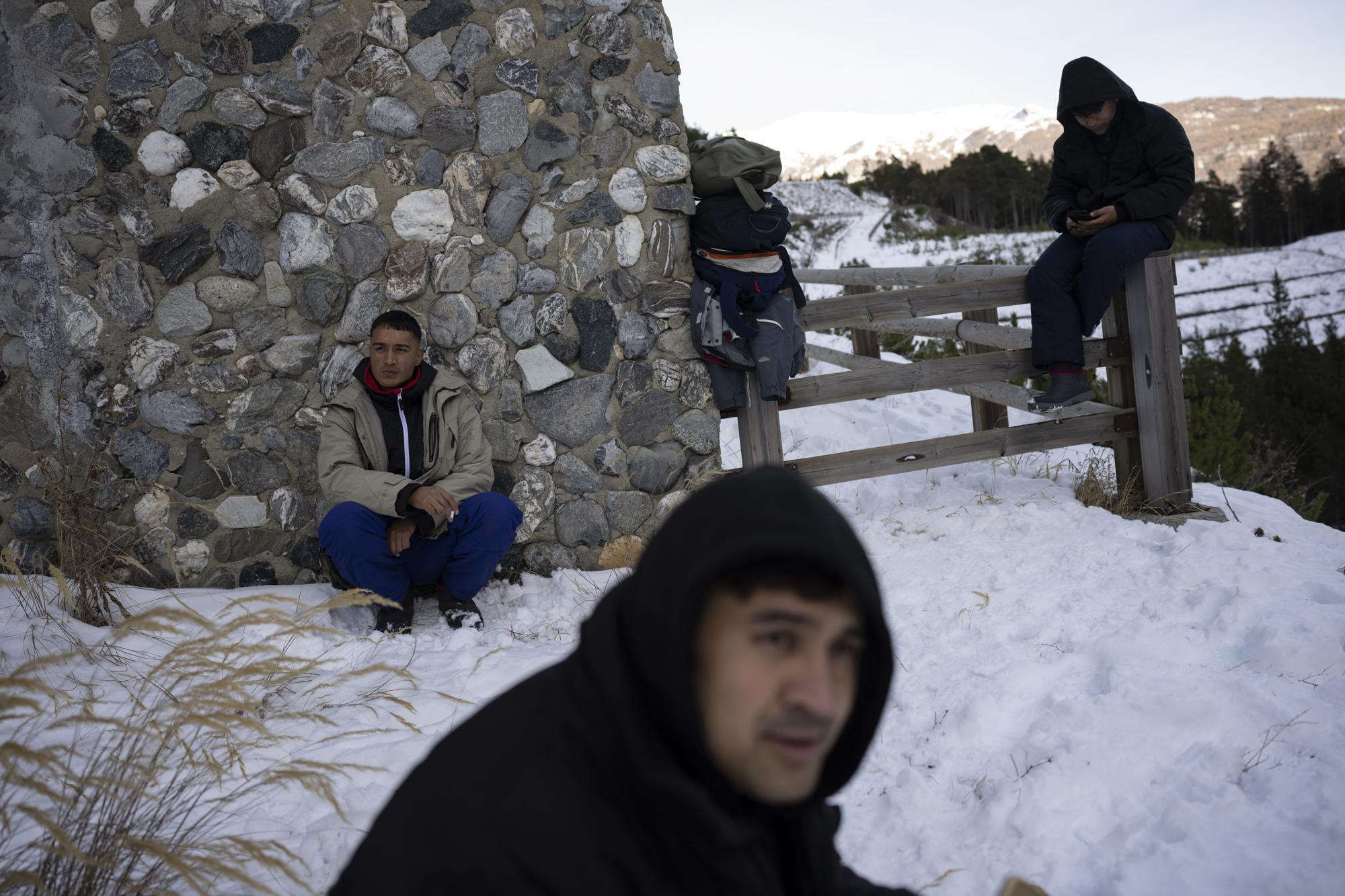 Afghan migrants headed to France from Italy rest along a mountain road leading to the French-Italian border, Wednesday, Dec. 15, 2021. (AP Photo/Daniel Cole)