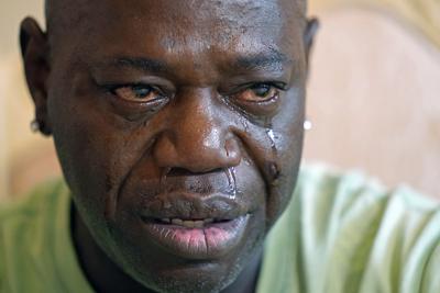 FIILE - Aaron Larry Bowman cries during an interview at his attorney's office in Monroe, La., Thursday, Aug. 5, 2021, as he discusses his injuries resulting from a Louisiana State trooper pummeling him with a flashlight during a traffic stop. Louisiana has dropped its case against Bowman,  whose severe beating before his arrest in 2019 led to criminal charges and lawsuits against a state trooper.   (AP Photo/Rogelio V. Solis, File)