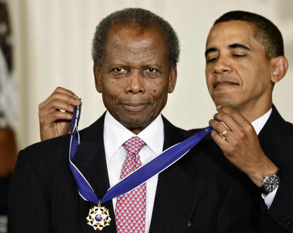 REMOVES REFERENCE TO THE BAHAMAS - FILE - President Barack Obama presents the 2009 Presidential Medal of Freedom to Sidney Poitier during ceremonies in the East Room at the White House in Washington on, Aug. 12, 2009.  Poitier, the groundbreaking actor and enduring inspiration who transformed how Black people were portrayed on screen, became the first Black actor to win an Academy Award for best lead performance and the first to be a top box-office draw, died Thursday, Jan. 6, 2022. He was 94. (AP Photo/J. Scott Applewhite, File)