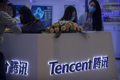 Visitantes a la Feria Internacional China de Comercio de Servicios (CIFTIS) reunidos alrededor de un stand de la firma de tecnología china Tencent el 5 de septiembre de 2020 en Beijing. (AP Foto/Mark Sjefeelbein)