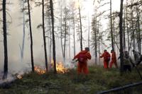 Firefighters and volunteers work at the scene of forest fire near Magan village in Yakutsk region, republic of Sakha also known as Yakutia, Russia Far East, on Tuesday, Aug. 10, 2021. Russian authorities have expanded a state of emergency in northeast Siberia to bring in outside resources to combat wildfires that have engulfed the vast region. Smoke from burning forests forced the airport in the capital of Yakutsk to suspend operations Thursday. (AP Photo/Vasily Kuper)